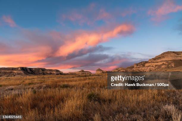 scotts bluff national monument windstorm,scenic view of field against sky during sunset,gering,nebraska,united states,usa - midwest usa stockfoto's en -beelden