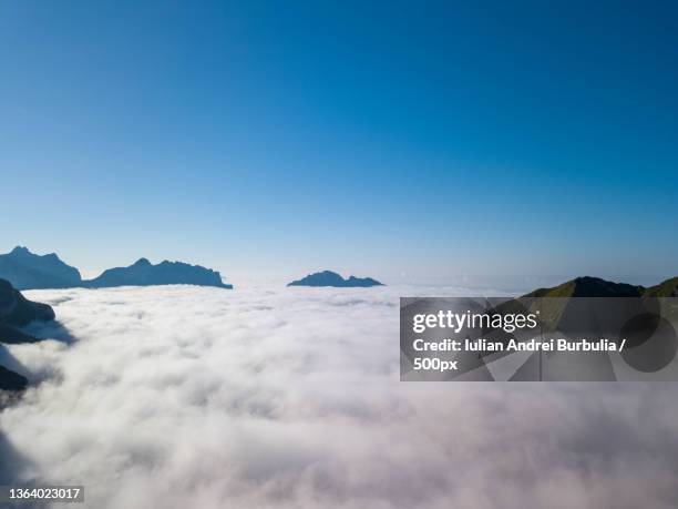 above the clouds,scenic view of snowcapped mountains against clear blue sky,via caltene,cesiomaggiore,belluno,italy - iulian andrei stock-fotos und bilder