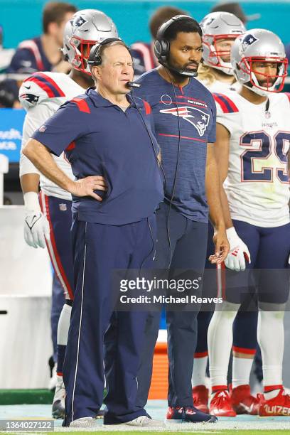 Head coach Bill Belichick and outside linebackers coach Jerod Mayo of the New England Patriots look on against the Miami Dolphins during the fourth...