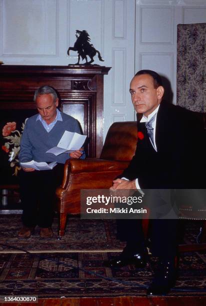 View of American film director James Ivory , looking at a script, and English actor Ben Kingsley on the set of their film 'Maurice,' London, England,...