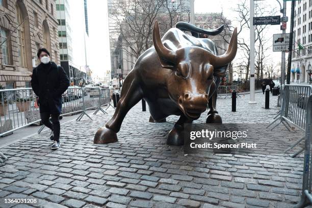 Man walks by the Wall Street Bull by the New York Stock Exchange on January 11, 2022 in New York City. After yesterdays sell off, the Dow was down...