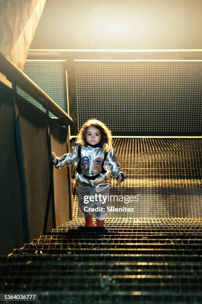 spacewoman in the city at night standing up stairs - girl rising stock-fotos und bilder