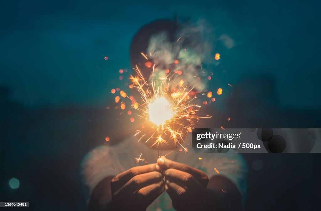 Cropped hands holding sparkler at night,Bangladesh