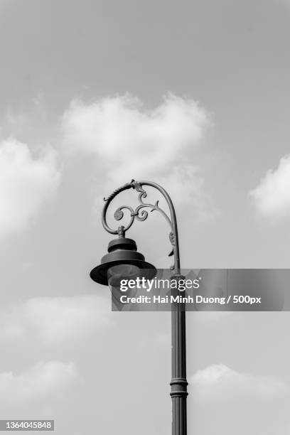 street lamp black and white,low angle view of street light against sky - white lamp foto e immagini stock