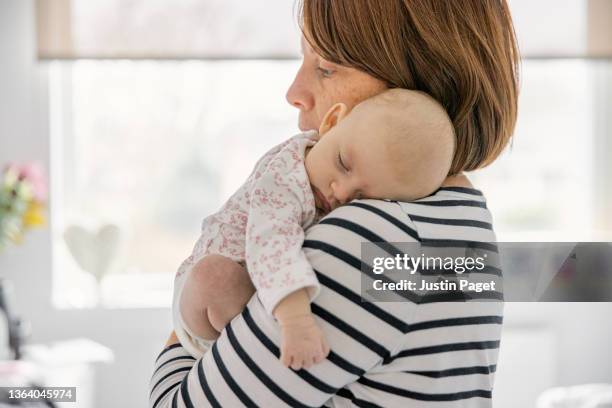 portrait of a beautiful baby girl being carried by her mother - sailor stripes stock pictures, royalty-free photos & images