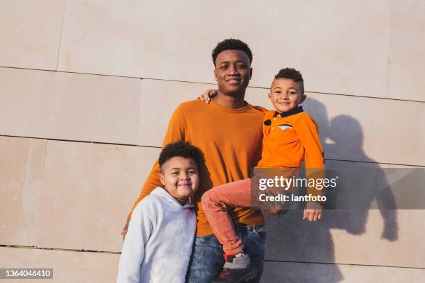 two brothers and his father posing together in an urban background. - single father stockfoto's en -beelden