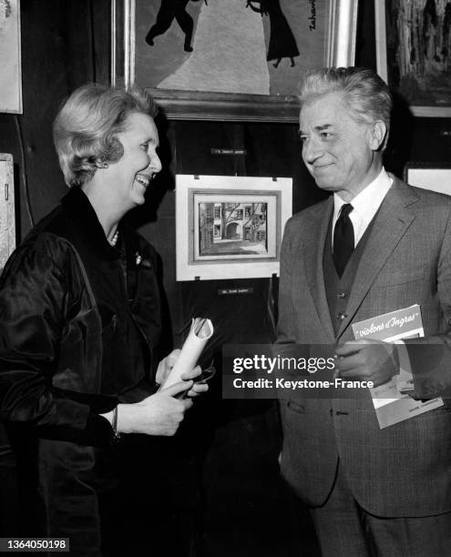 Alix de Rothschild et Claude Dauphin discutant lors d'une vente aux enchères à Paris, le 25 janvier 1966.