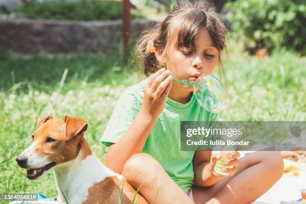 girl blowing bubbles - child blowing bubbles stock-fotos und bilder