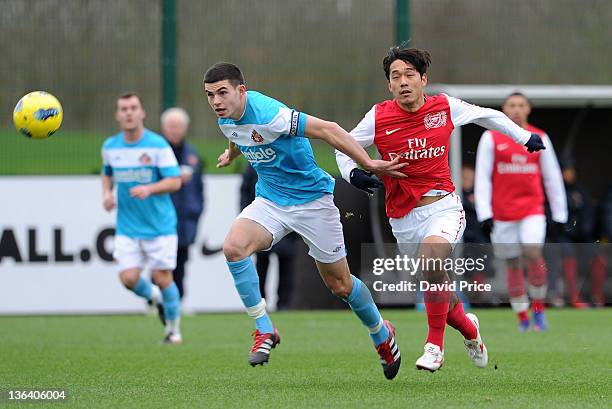 Ju Young Park of Arsenal chases the ball with John Egan of Sunderland during the Barclays Premier Reserve League match between Arsenal Reserves and...