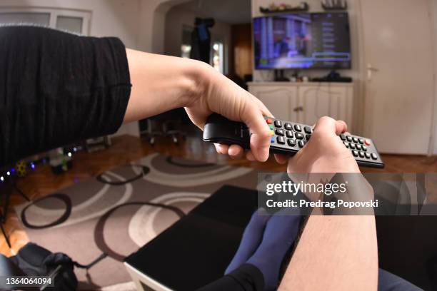 man and woman hands with television remote control - remote control stock pictures, royalty-free photos & images