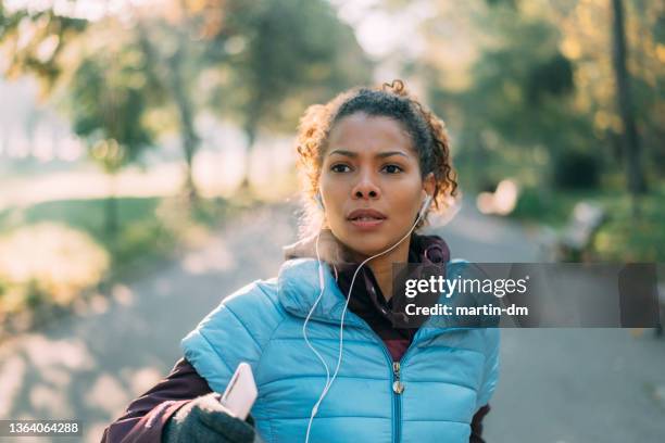 jogging nel parco autunnale - audiobook foto e immagini stock