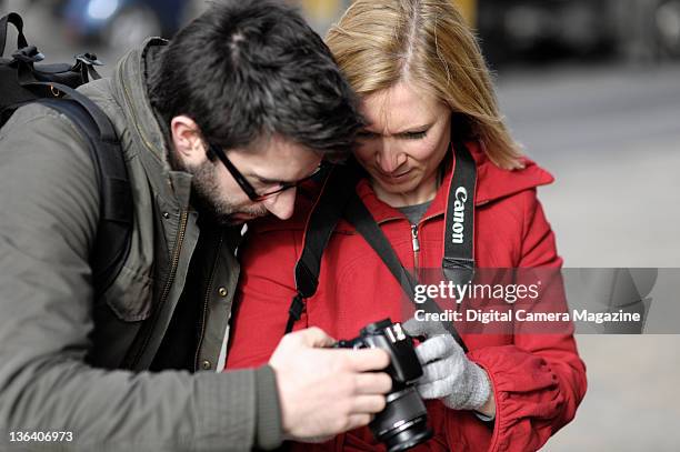 Two photographers comparing pictures on a Canon EOS 450D camera, on March 6, 2009.