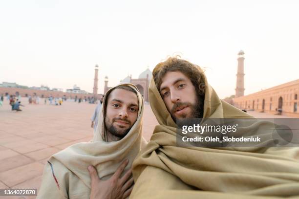 selfie of two man on the background of mosque in lahore - pakistan monument stock pictures, royalty-free photos & images