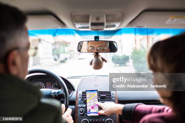 a senior man's eyes in the rear view mirror while looking at the satnav - rear view mirror eyes stock pictures, royalty-free photos & images