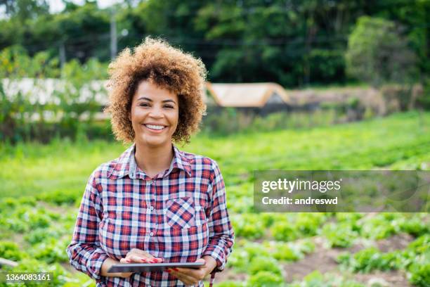 woman growing plants using technology - digital tablet - african american farmer stock pictures, royalty-free photos & images