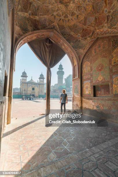 man walking in the mosque in lahore - pakistan monument stock pictures, royalty-free photos & images