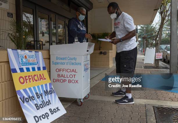 Wilbur Harbin prepares to place his ballot in a vote by mail ballot drop box during the Congressional district 20 elections on January 11, 2022 in...