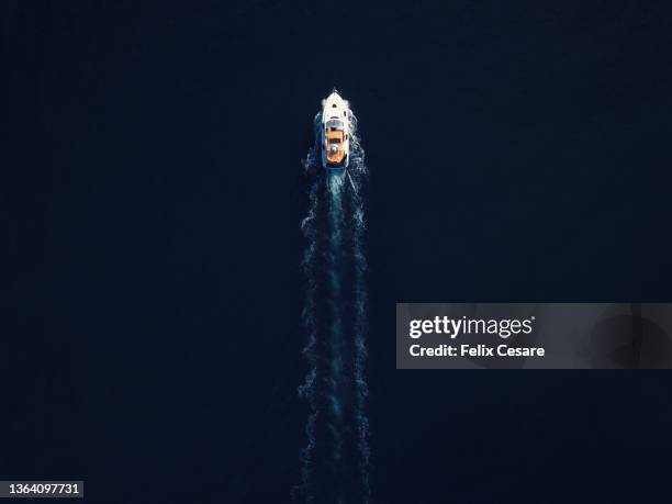 aerial view of a motorboat surrounded by deep blue water. - kielwasser stock-fotos und bilder