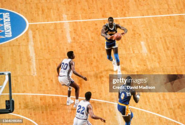 Magic Johnson of the Los Angeles Lakers passes to teammate Orlando Woolridge during an NBA game against the Sacramento Kings played on March 23, 1989...