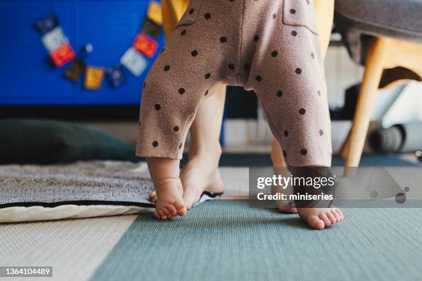 une journée dans la vie d’un bébé : apprendre à marcher - nurse feet photos et images de collection