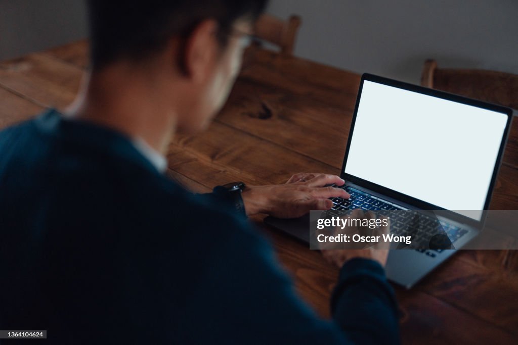 Over the shoulder view of young business man working with laptop