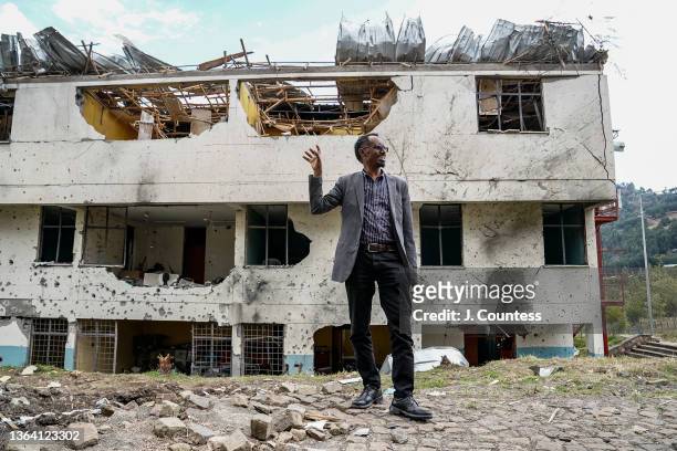 Dr. Mengesha Ayene, president of Wollo University, points out damage to two major department offices as he stands next to an impact crater where...