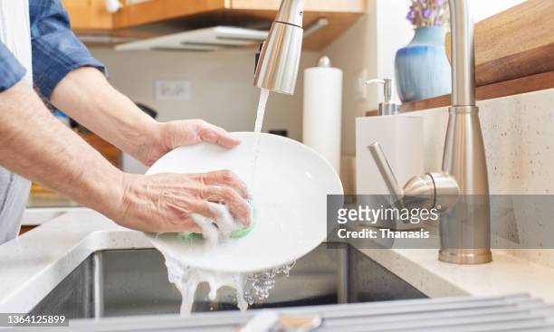doing  the dishes, house chores - wash the dishes stock-fotos und bilder