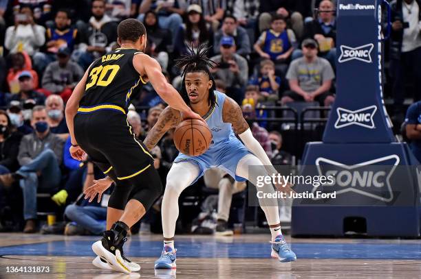 Ja Morant of the Memphis Grizzlies guards Stephen Curry of the Golden State Warriors during the second half at FedExForum on January 11, 2022 in...