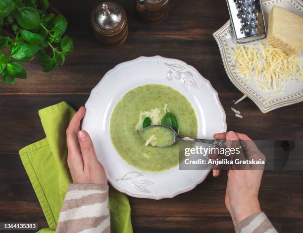 woman eating a broccoli soup, top view. - alleen één oudere vrouw stockfoto's en -beelden