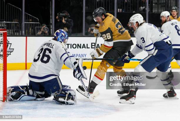 Jack Campbell of the Toronto Maple Leafs makes a save against Mattias Janmark of the Vegas Golden Knights as Justin Holl of the Maple Leafs defends...