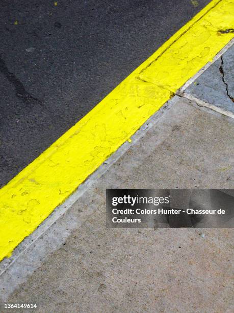 yellow line painted between a street and sidewalk in manhattan - sidewalk stock pictures, royalty-free photos & images