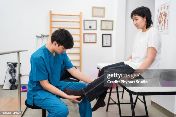 teenager girl going to the doctor with leg pain - sports medicine stockfoto's en -beelden