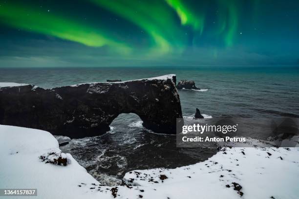 northern lights over cape dyrholaey at winter. iceland - northern lights iceland stockfoto's en -beelden