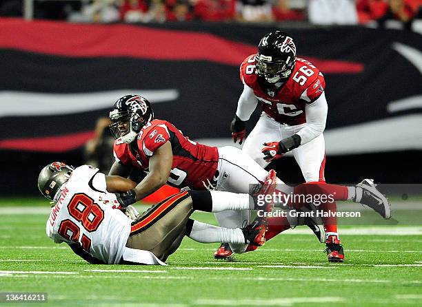 Curtis Lofton of the Atlanta Falcons tackles Kregg Lumpkin of the Tampa Bay Buccaneers during play at the Georgia Dome on January 1, 2012 in Atlanta,...