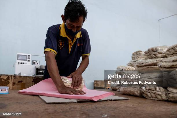 Worker packs noodles at Marga Mulja factory on January 12, 2022 in Surabaya, Indonesia. Longevity white noodles are a popular dish that is...