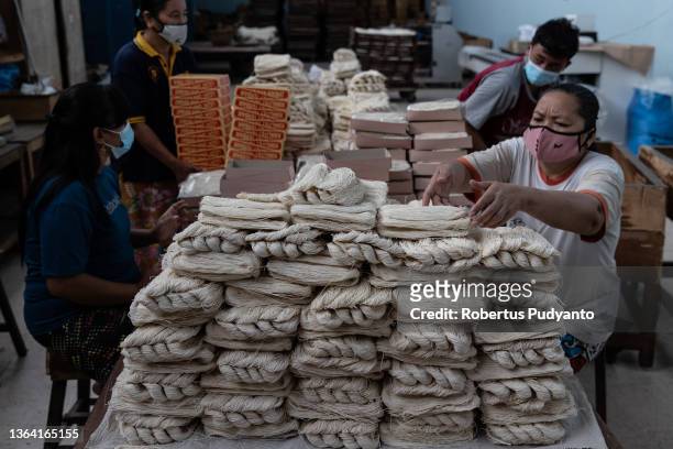 Workers pack noodles at Marga Mulja factory on January 12, 2022 in Surabaya, Indonesia. Longevity white noodles are a popular dish that is...