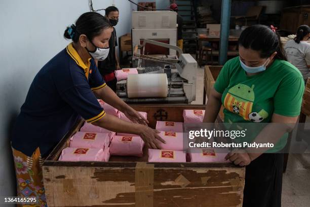 Workers arrange wrapped noodles at Marga Mulja factory on January 12, 2022 in Surabaya, Indonesia. Longevity white noodles are a popular dish that is...