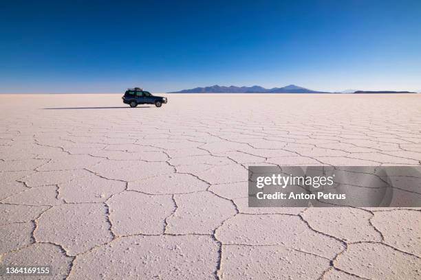 car at salar de uyuni, aitiplano, bolivia. traveling in bolivia - cloud sales fotografías e imágenes de stock