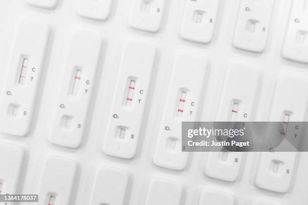 abstract photo of rows of used lateral flow tests - several showing positive results - medical test stock pictures, royalty-free photos & images