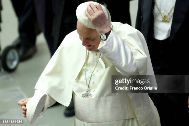 Pope Francis exchanges his biretta with a faithful during the weekly audience at the Paul VI Hall on January 12, 2022 in Vatican City, Vatican. In a...