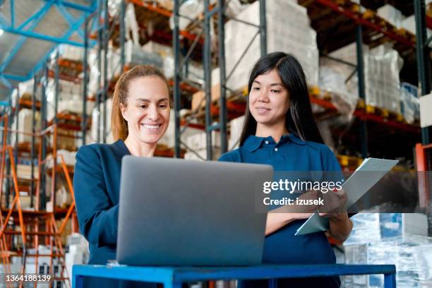 female warehouse manager talking with employee - navy blue polo shirt stock pictures, royalty-free photos & images