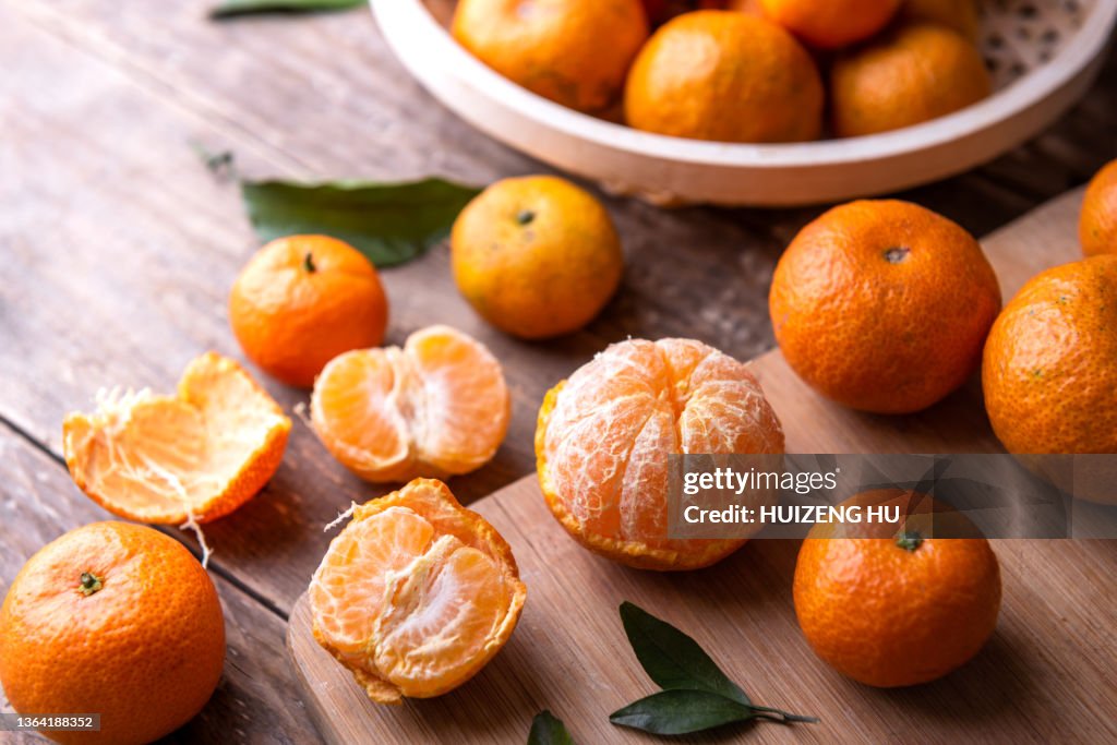 Fresh mandarin oranges fruit or tangerines with leaves on a wooden table