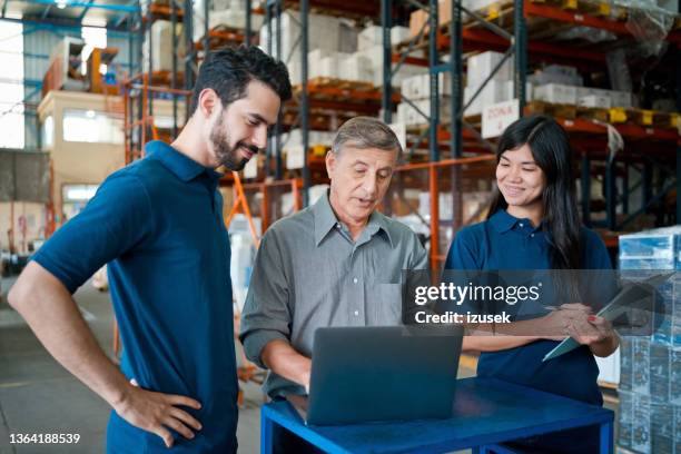 male warehouse manager talking with employees - gray polo shirt stock pictures, royalty-free photos & images