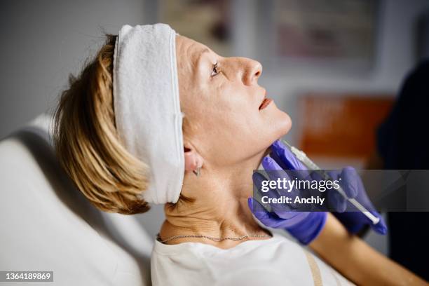 female doctor giving patient lipolysis double chin treatment - woman injecting stock pictures, royalty-free photos & images