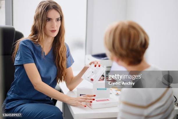 young female doctor having a consultation with a mature adult woman patient - dermatologists talking to each other patient stock pictures, royalty-free photos & images