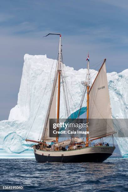 ship sailing past iceberg on sunny atlantic ocean greenland - disko bay stock pictures, royalty-free photos & images