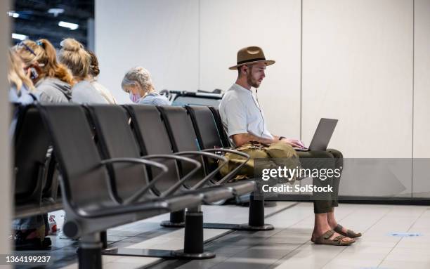 using laptop at the airport - airport hipster travel stockfoto's en -beelden