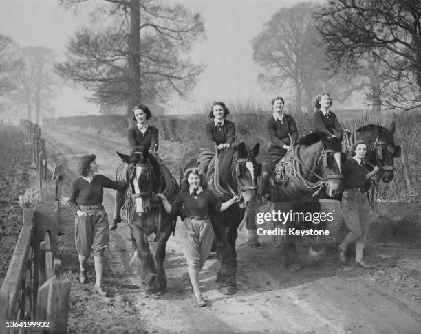 Members of the Women's Land Army lead and ride their draught horses back from ploughing the fields of a London County Council farm on 21st March 1941...