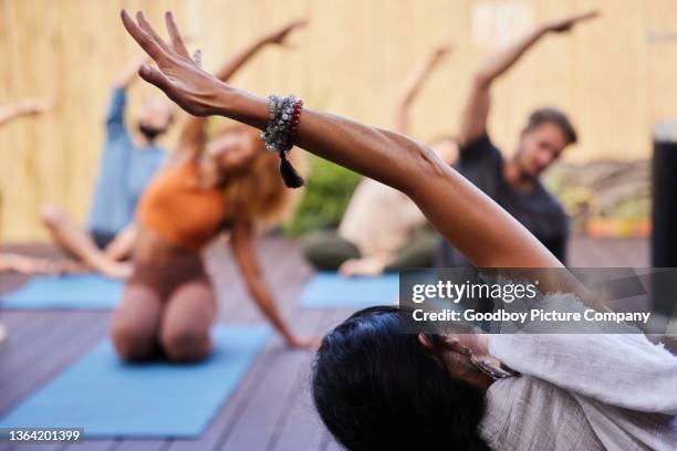 teacher leading students during a yoga class outside - professor de ioga imagens e fotografias de stock