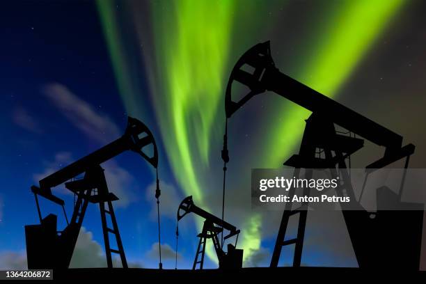 oil pump on the northern lights background. oil production in the far north - arctic oil stock pictures, royalty-free photos & images